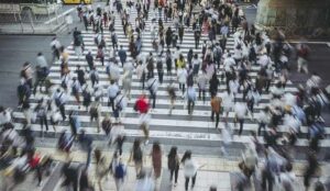 Many busy people crossing the road