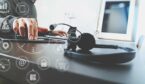 A person works on a tablet with a headset in the foreground