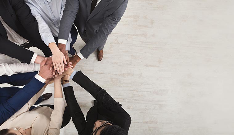 A picture of a group of people putting their hands together