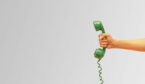 a hand holds out a green old fashioned phone