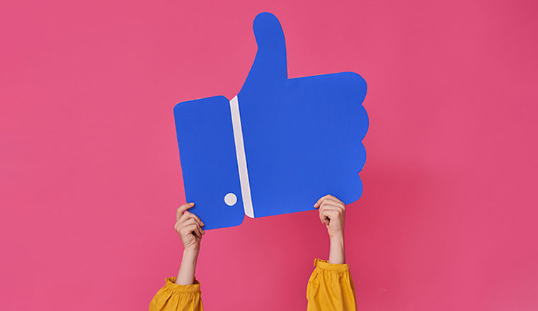 A photo of a Facebook "like" icon being held up