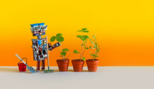 A photo of a toy robot next to plants