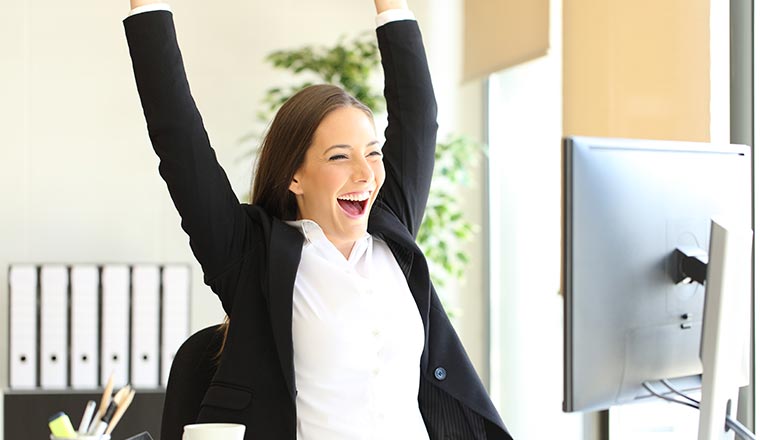 A photo of a happy person at their computer