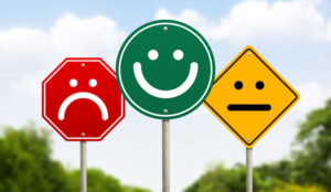 Three traffic signs have faces on them. The one on the right is red and unhappy, the one in the middle is green and happy and the one on the left is yellow and average