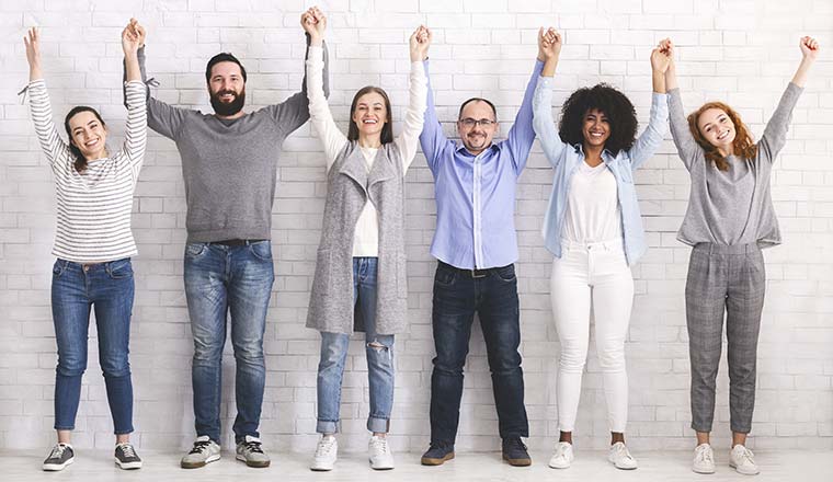 A photo of a group of people holding their hands in the air