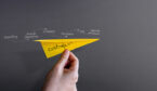 A picture of a paper aeroplane flying under a time line