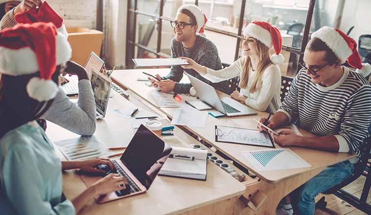 A picture of office workers wearing Christmas hats