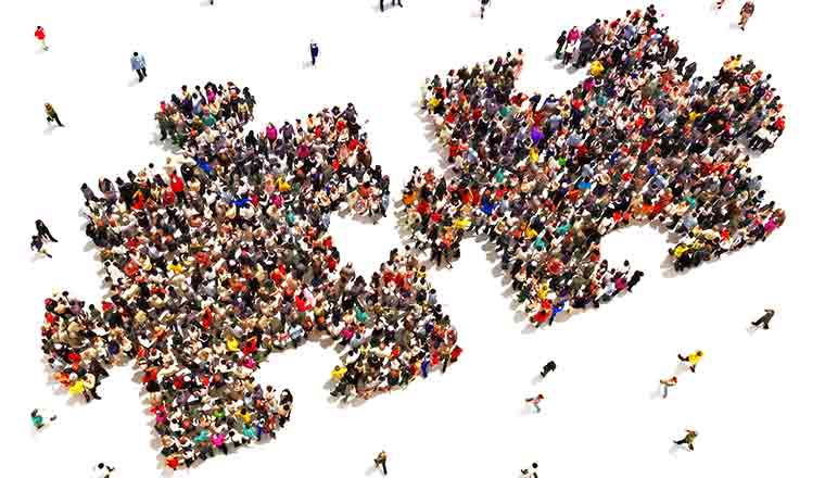 A picture of people grouped together to form a puzzle shape