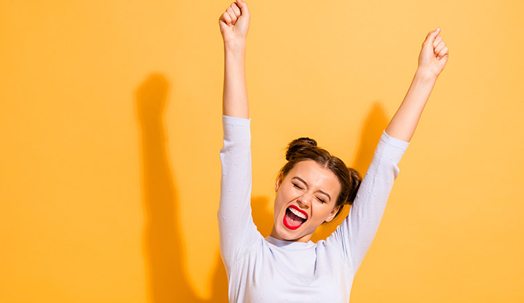 A photo of a person celebrating with hands in the air