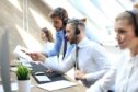 A picture of two male call centre agents looking at a screen