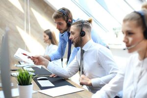 A picture of two male call centre agents looking at a screen