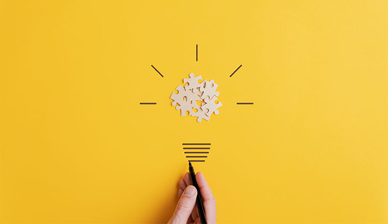 A photo of a light bulb made from puzzel pieces