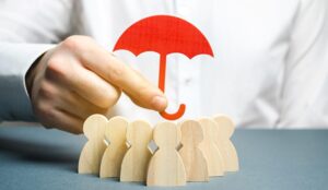 A photo of a red umbrella being held over wooden figures