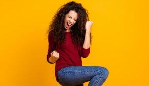 A woman fist pumps with joy