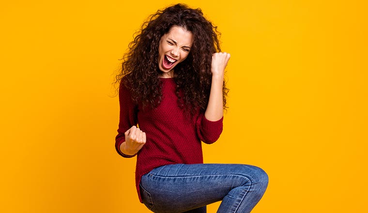 A woman fist pumps with joy