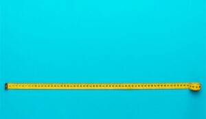 A photo of a yellow measuring tape on a blue background