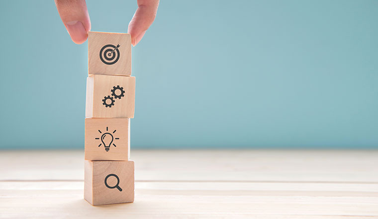 A photo of blocks being stacked with strategy symbols