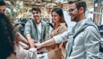 A photo of an office team putting their hands together