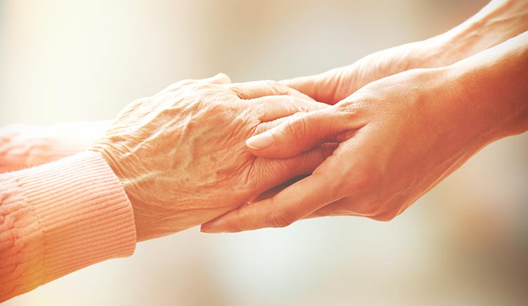 A photo of someone holding an elderly persons hands