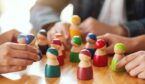 A photo of people playing with wooden figurines