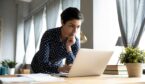 A photo of someone thinking at a laptop