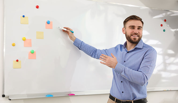 A photo of a teacher at a whiteboard