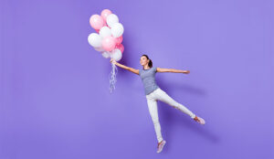 A photo of an engaged staff member being carried away by balloons