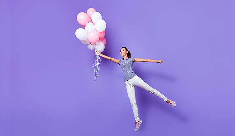 A photo of an engaged staff member being carried away by balloons