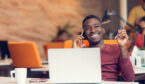 A picture of a happy agent on the phone sat at a desk