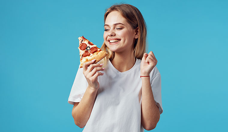 A picture of a happy person enjoying pizza