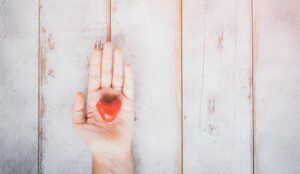 A photo of a red heart in someone's hand