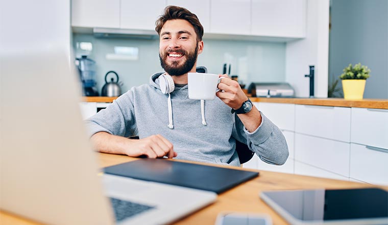 A photo of a remote worker raising their coffee cup