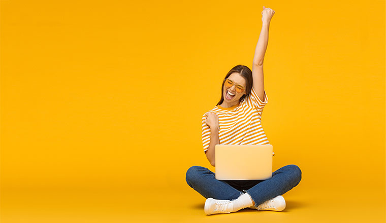 A photo of someone celebrating at their computer