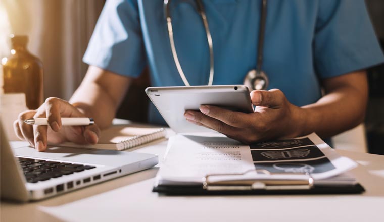 A picture of a doctor holding a tablet device