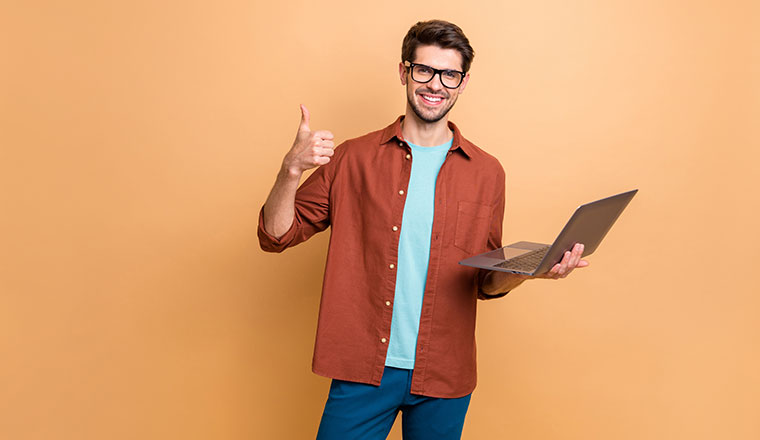 A photo of someone with a laptop and their thumbs up