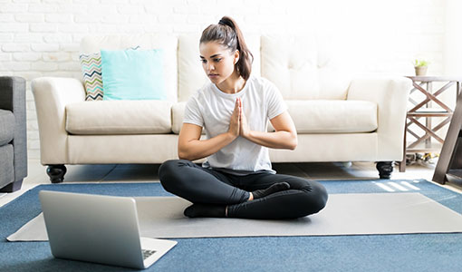 A photo of someone meditating at a laptop