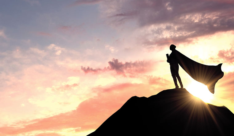 silhouette of lady standing on top of mountain with cape on