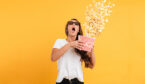 A photo of someone in shock, eating popcorn