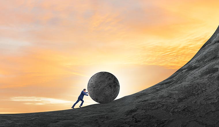 A picture of someone rolling a boulder up the hill