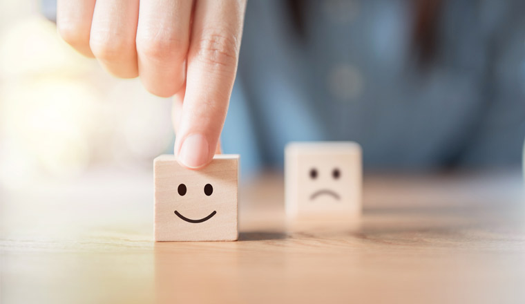 A picture of a smiley face on a wooden cube