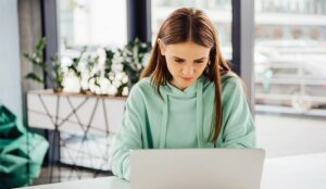 A photo of someone working in a hoodie