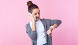 A photo of someone on the phone and checking the time