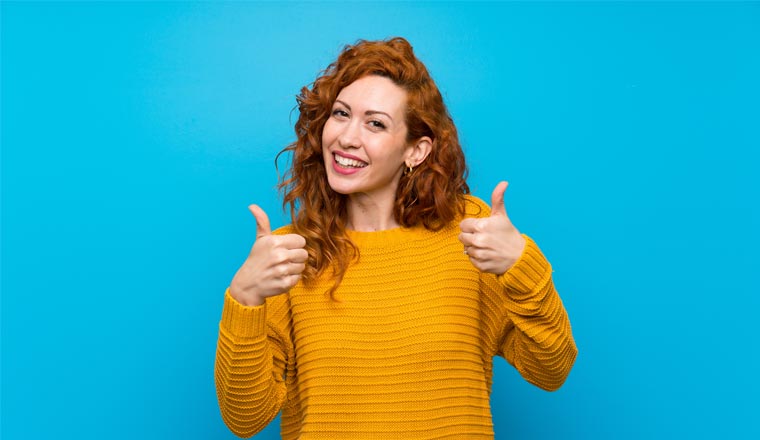 A picture of a lady holding her thumbs up