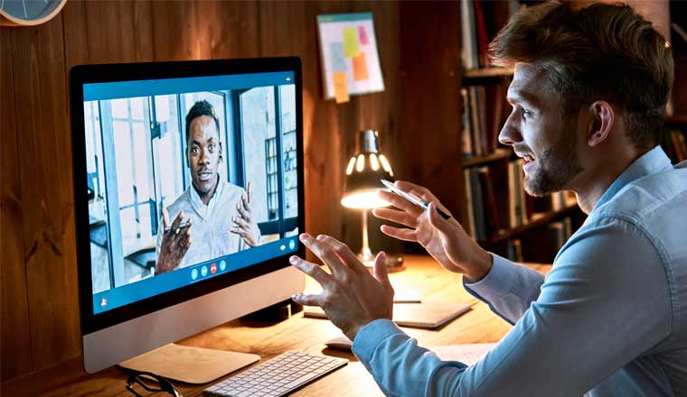 A picture of two workers communicating on a virtual meeting