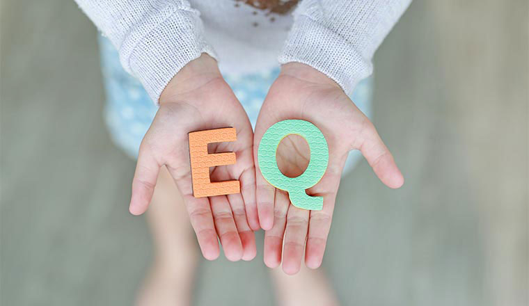 A photo of someone holding the letters "EQ"