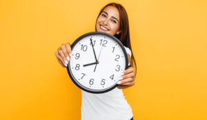 A photo of a woman holding a clock
