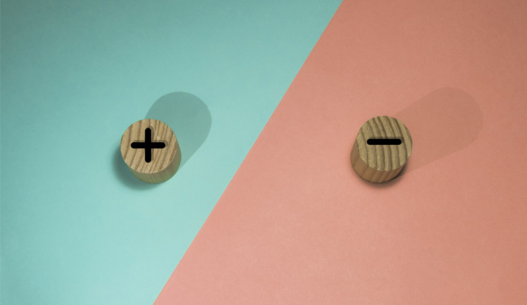 A picture of a plus and minus on wooden buttons