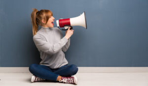 A picture of a girl shouting down a megaphone