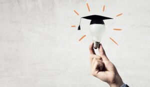A photo of a light bulb with a graduation hat
