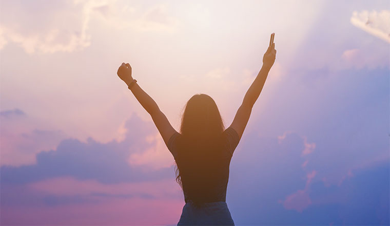 A photo of someone with there hands-up with joy